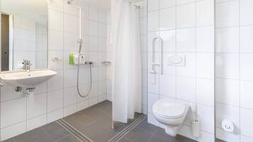 Une salle de bain moderne équipée d’une douche, de toilettes, d’un lavabo et d’un miroir.