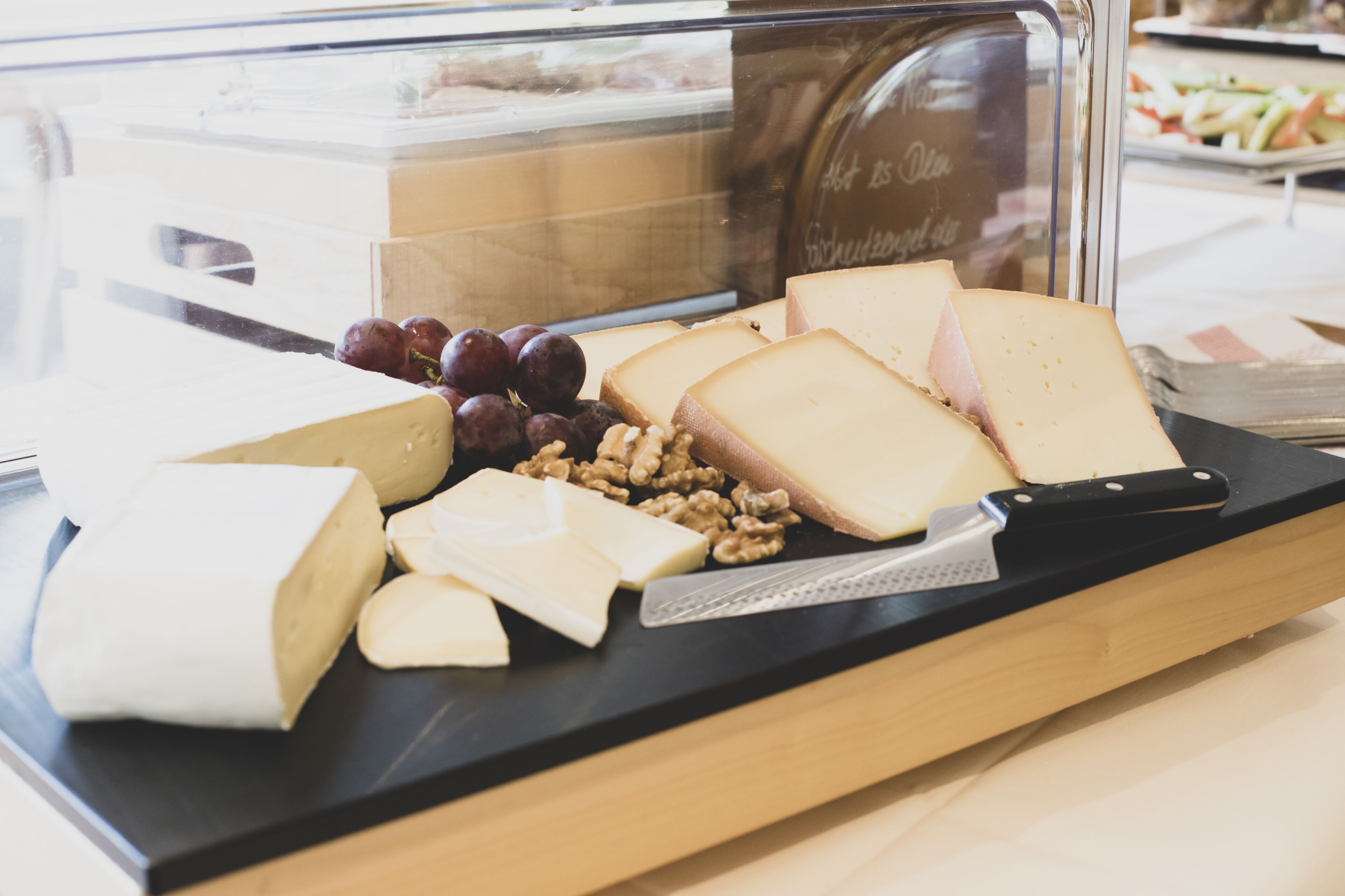 A cheese and fruit display in a deli counter.