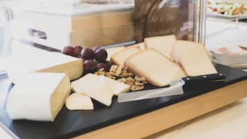 A cheese and fruit display in a deli counter.