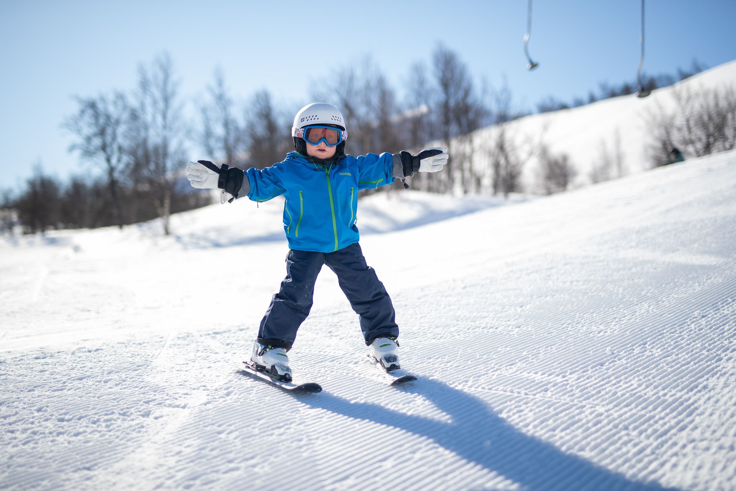 Un enfant qui fait du ski sur une pente enneigée.