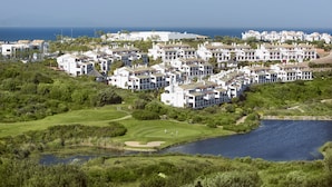 En kystresort med hvide bygninger, en golfbane og en sø.