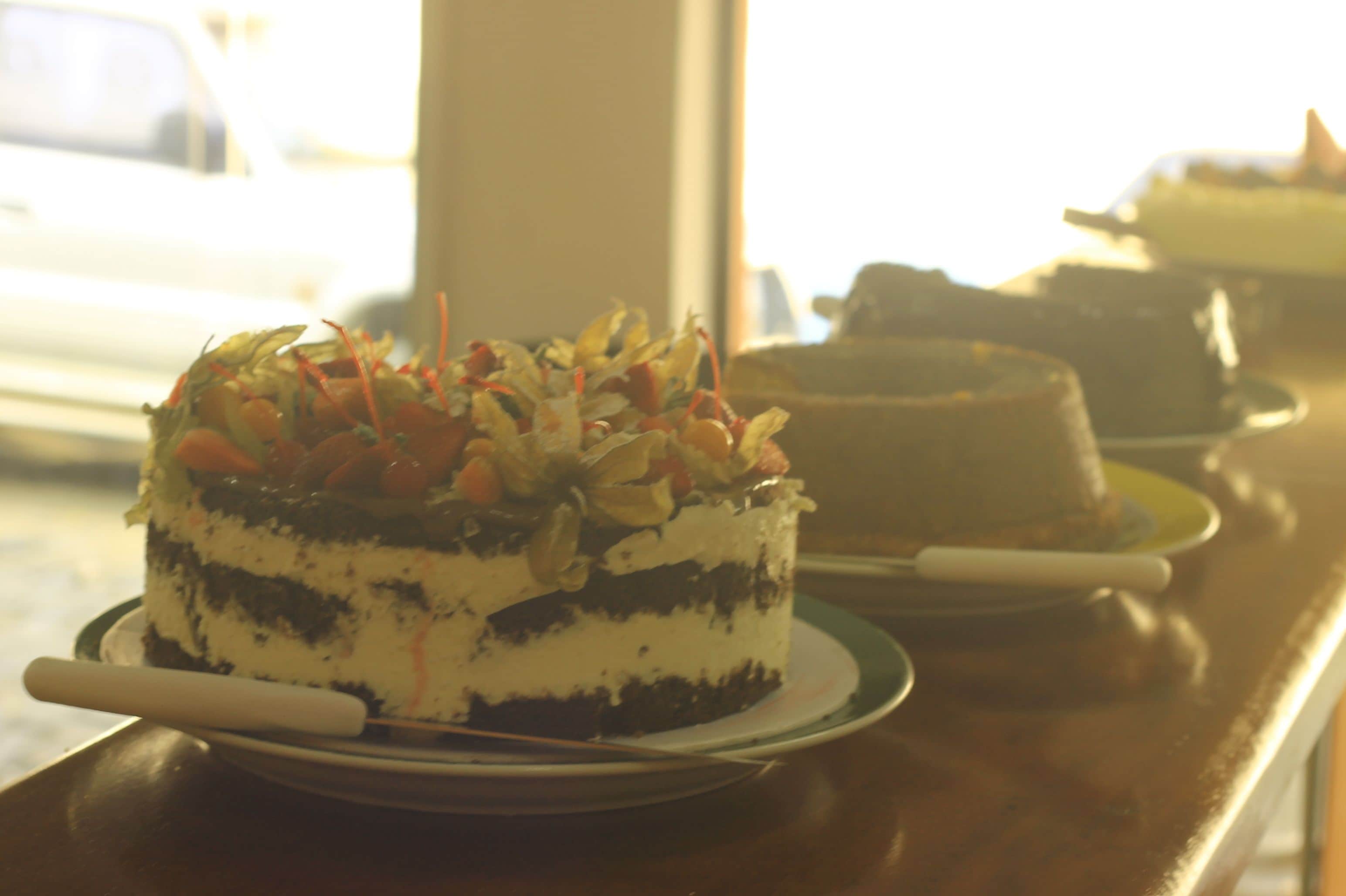 A cake on a plate with a knife, placed on a table.