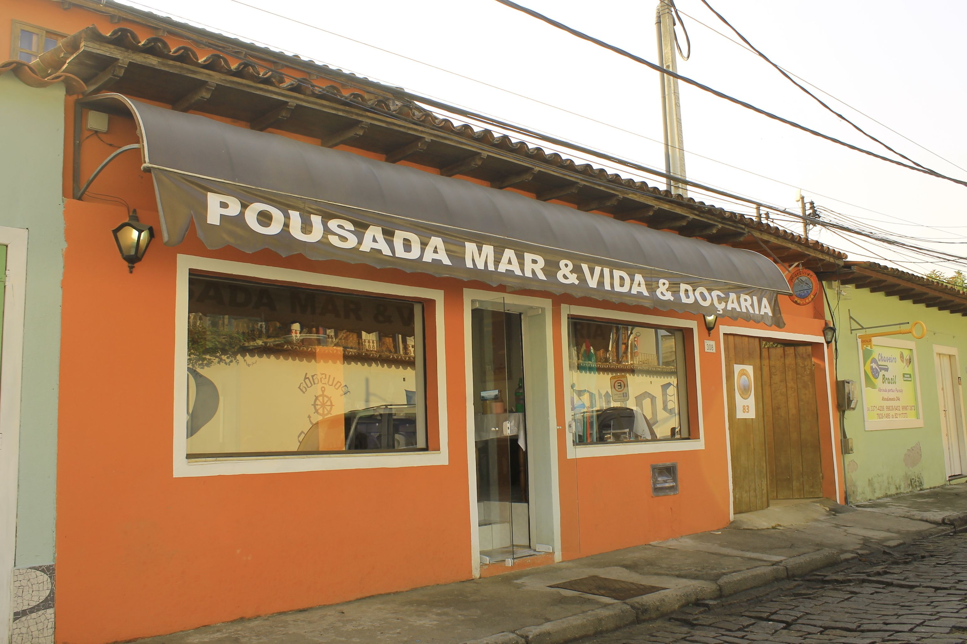 A building with a sign reading "Pousada Mar & Vida & Doçaria".