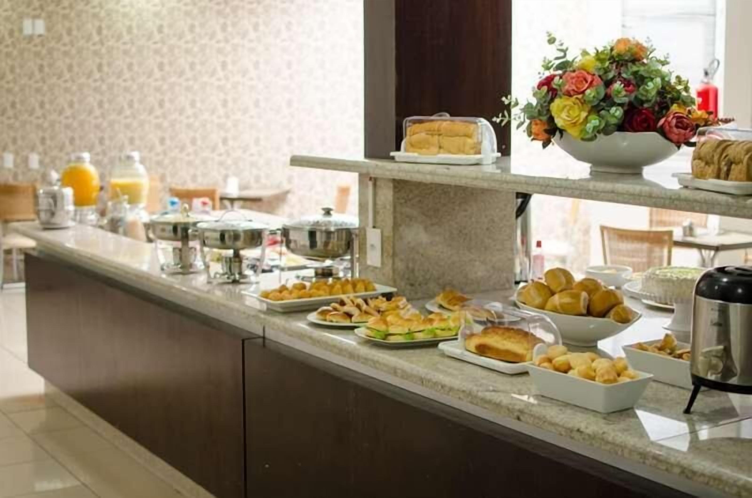 Buffet montado com diversos alimentos e uma máquina de café.