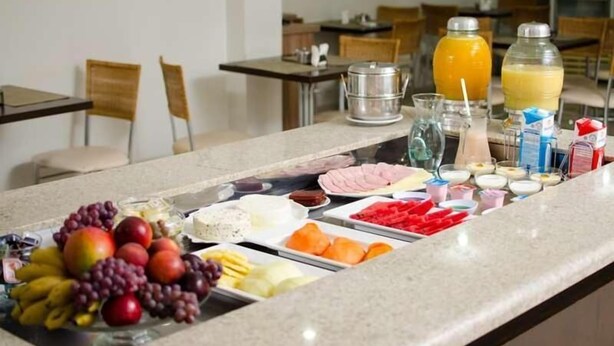 A buffet setup with various food items and beverages. - Serras Hotel (Rondonopolis)