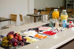 Una mesa de buffet con diferentes alimentos y bebidas.
