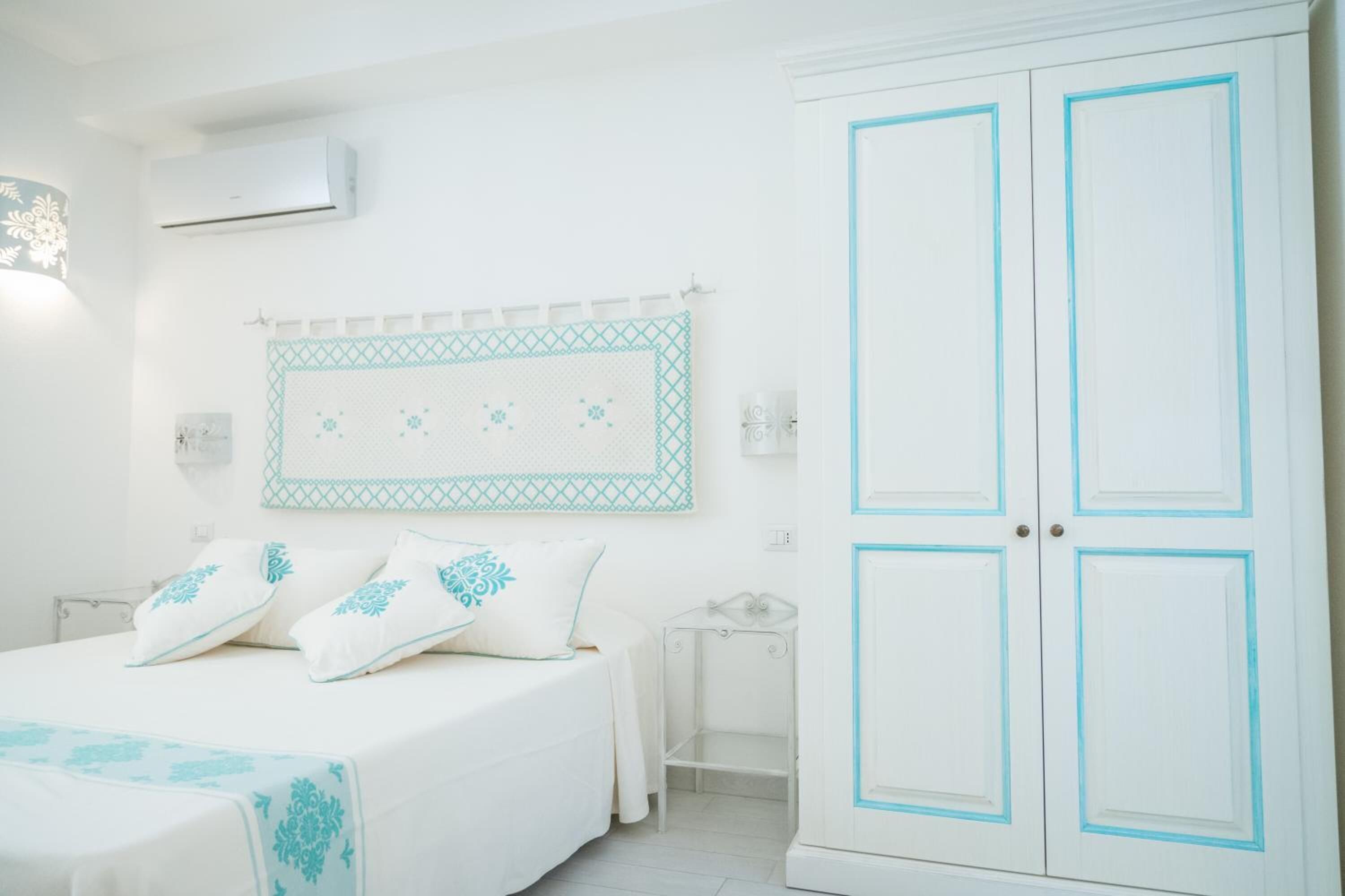 Un dormitorio con cama, armario y aire acondicionado instalado en la pared.