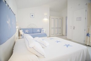Un dormitorio con cama, sofá azul, armario y puerta.