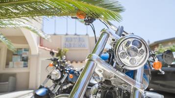 Una fila de motocicletas estacionadas frente a un edificio con un letrero que dice 'HOTEL REGINA'.