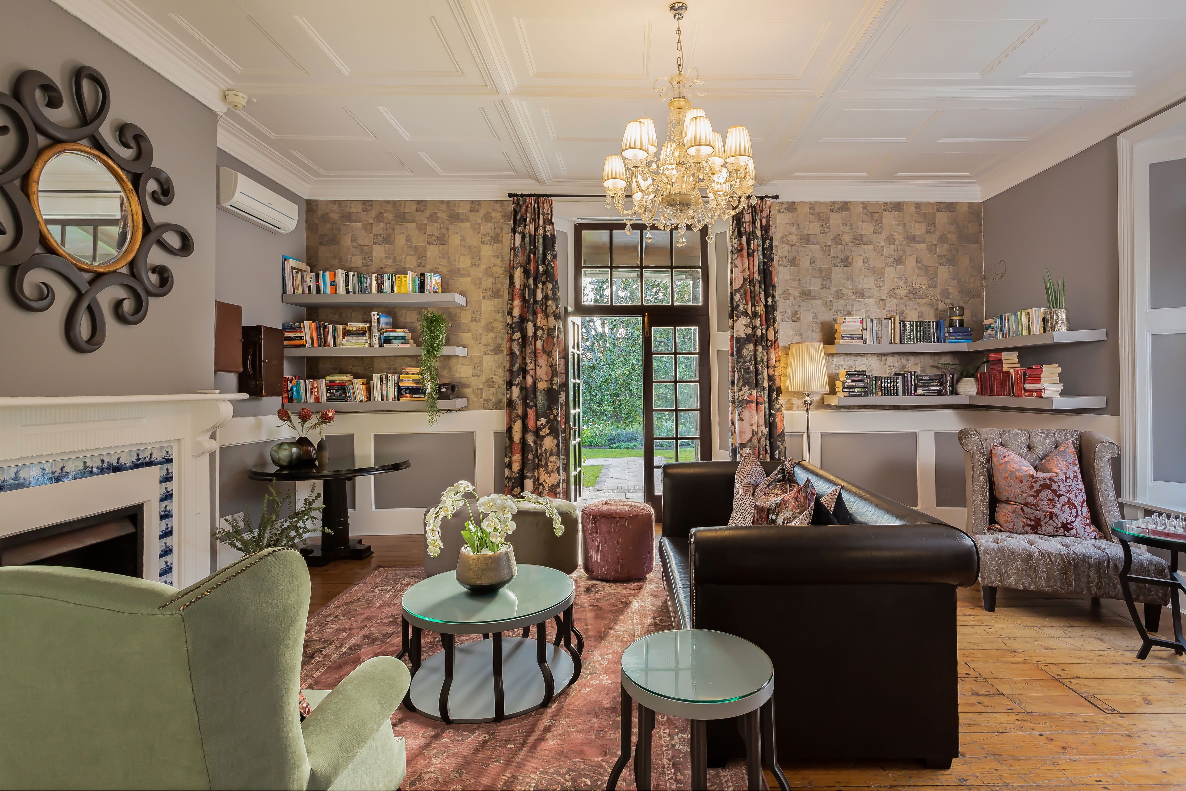A well-furnished living room with a fireplace, bookshelves, and a comfortable seating area.