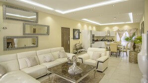 A modern living room with a sectional sofa, a coffee table, and a dining area with a table and chairs. - The Landmark Suites Westlands, Nairobi- Next to Westgate Mall (Nairobi)