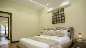 A modern bedroom with a large bed, a nightstand, and a wall art piece. - The Landmark Suites Westlands, Nairobi- Next to Westgate Mall (Nairobi)