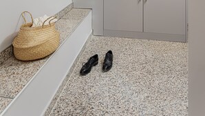 A corner of a room with a white wall, a white ceiling, a white floor, a white door, and a white cabinet. - VISIONAPARTMENTS Lucerne Neustadtstrasse (Lucerne)