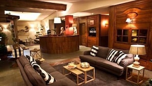 A cozy lobby with a reception desk, sofas, and a coffee table. - Hotel Rendez Vous (Chatillon)