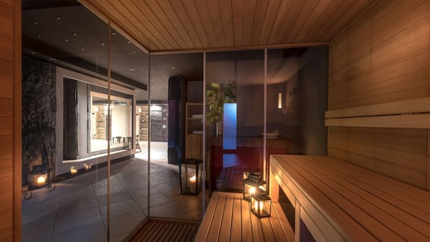 A modern interior with a wooden bench, glass partitions, and a stone fireplace. - Hotel Rendez Vous (Chatillon)