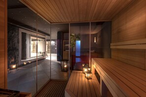 Un interior moderno con un banco de madera, divisiones de vidrio y una chimenea de piedra.