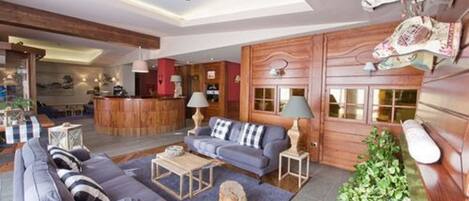 Una sala de estar moderna con sofá, mesa de centro y lámparas decorativas.