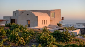 Edifici modern amb façana corba, grans finestres i teulada plana.