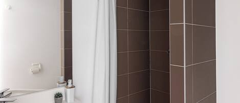 A bathroom with a bathtub, a shower, and a sink.