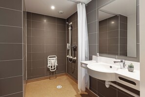 Une salle de bain moderne équipée d’une douche, d’un lavabo et d’un porte-serviettes.