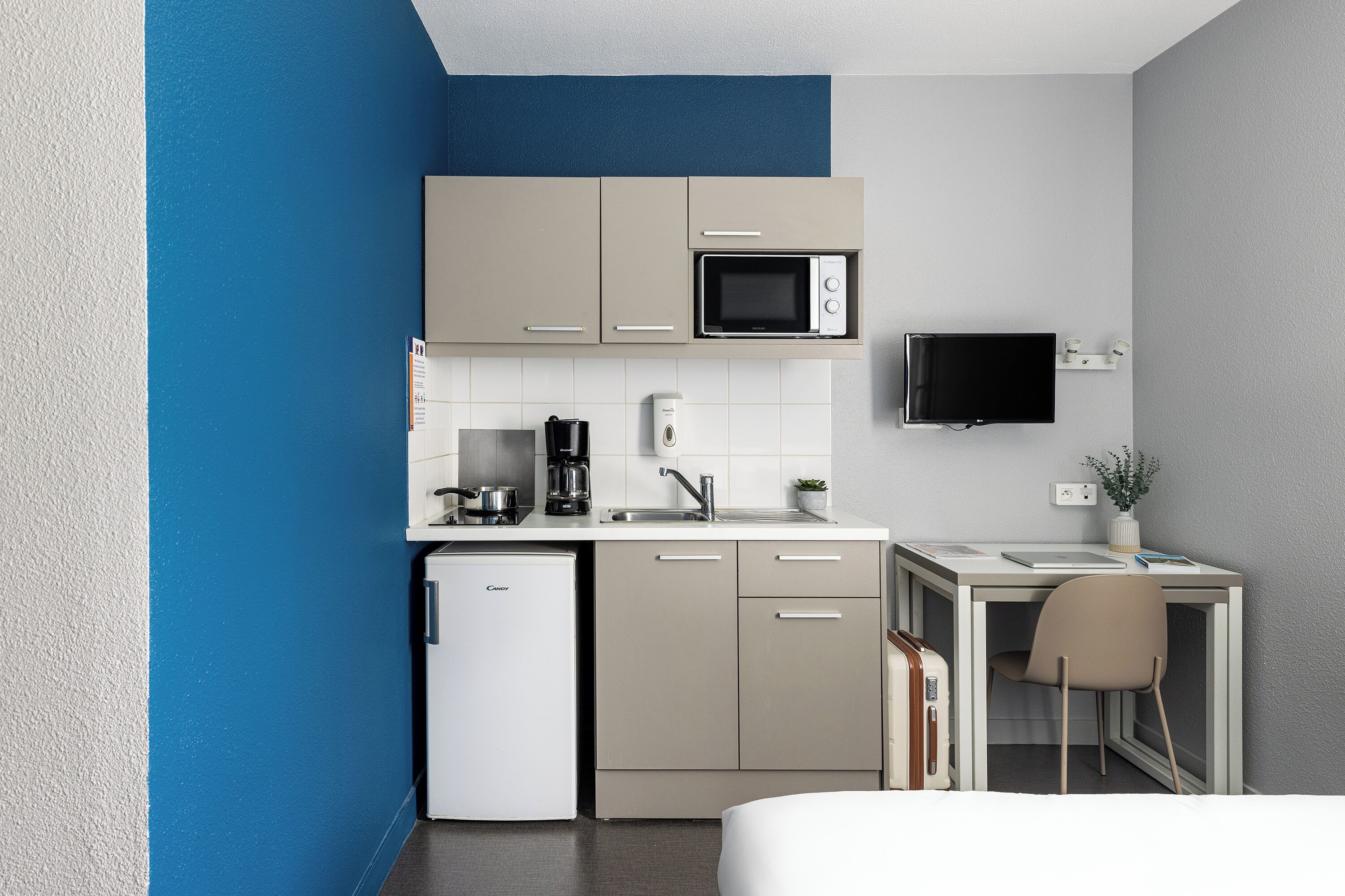 A compact kitchenette with a microwave, coffee maker, and a small refrigerator.