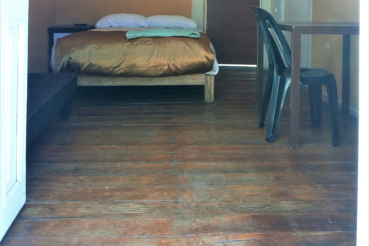 A room with a bed, a desk, and a chair.