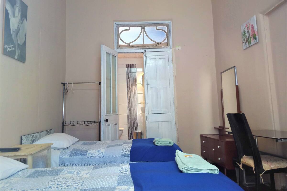 A bedroom with a bed, a desk, a chair, and a wardrobe.