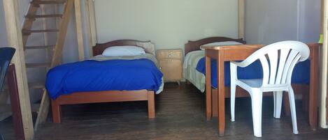 A room with two wooden beds, a desk with a chair, a ladder, and a small nightstand.