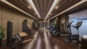 Un gimnasio con equipo de ejercicio, una banca y una cinta de correr.