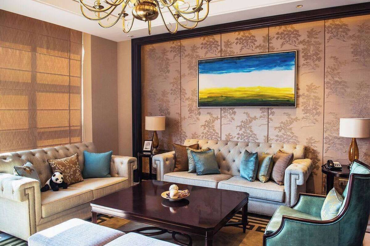 Un salón amplio con un gran sofá, una mesa de centro y una lámpara decorativa.
