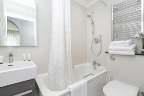 Un baño moderno con bañera, ducha y inodoro.