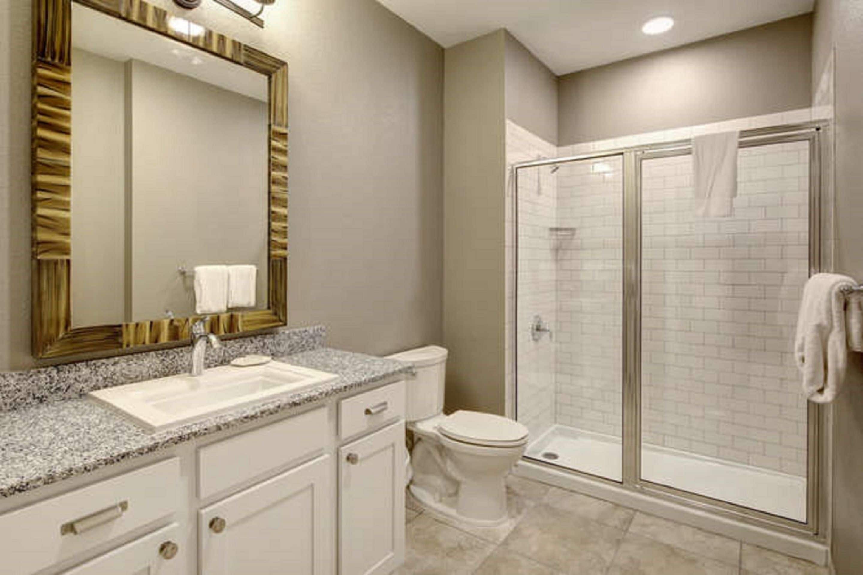 A bathroom with a sink, toilet, and a glass-enclosed shower.
