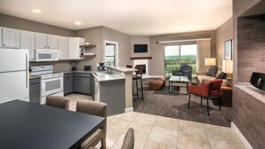 A modern kitchen with a dining area, a fireplace, and a balcony with a view. - WorldMark Marble Falls (Horseshoe Bay)