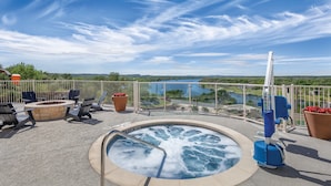 A hot tub surrounded by outdoor seating and a view of a lake. - WorldMark Marble Falls (Horseshoe Bay)