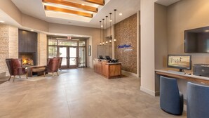 A reception area with a fireplace, leather chairs, a wooden reception desk, and a computer monitor. - WorldMark Marble Falls (Horseshoe Bay)