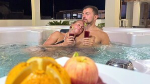 A couple in a hot tub with a plate of fruit in the foreground. - Hotel Flamingo (Puerto Ayora)