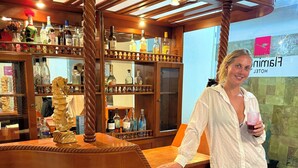 A wooden bar area with a ship-shaped counter, shelves with bottles, and a sign for 'Flimmin Hotel'. - Hotel Flamingo (Puerto Ayora)