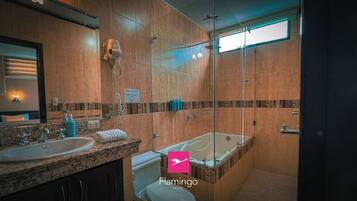 A modern bathroom with a large mirror, two sinks, a shower, and a bathtub.