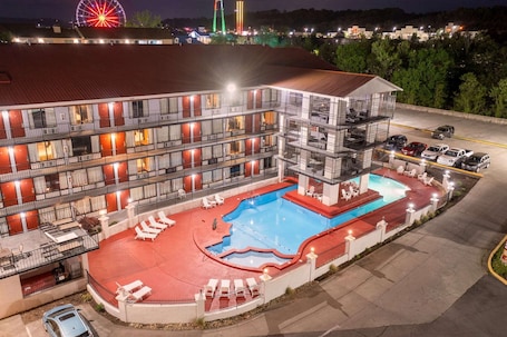 A multi-story hotel with a swimming pool and outdoor seating.