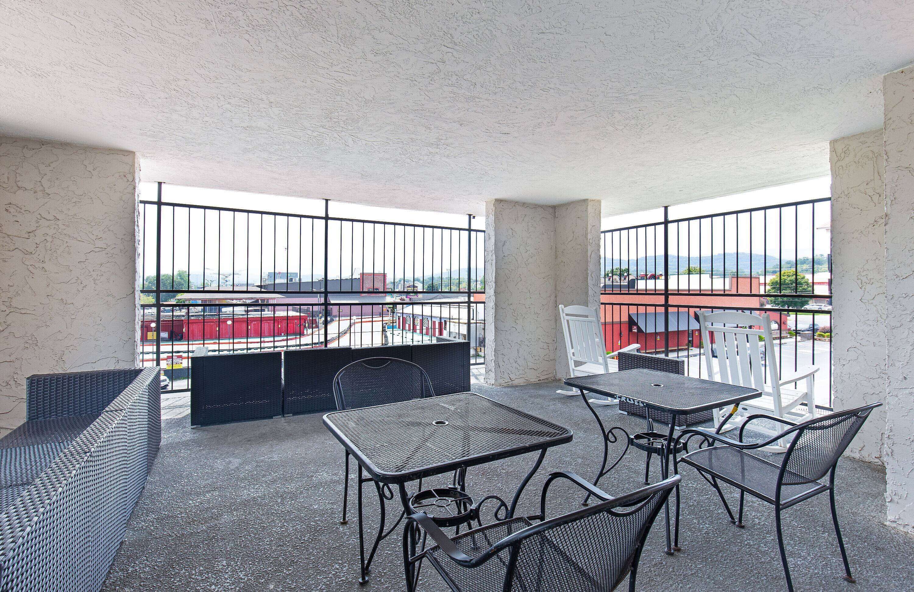 Un balcon avec un espace extérieur aménagé, comprenant une table et des chaises, et offrant une vue sur le paysage urbain.