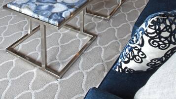 A hotel lobby with a bar area, seating, and a patterned carpet.