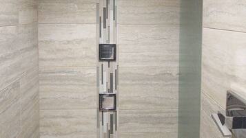 A modern shower with a vertical panel design and a glass shower enclosure.