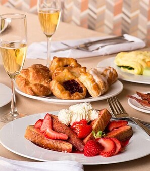 A table with pastries, a glass of wine, and a plate of strawberries. - Silver Reef Casino Resort (Ferndale)