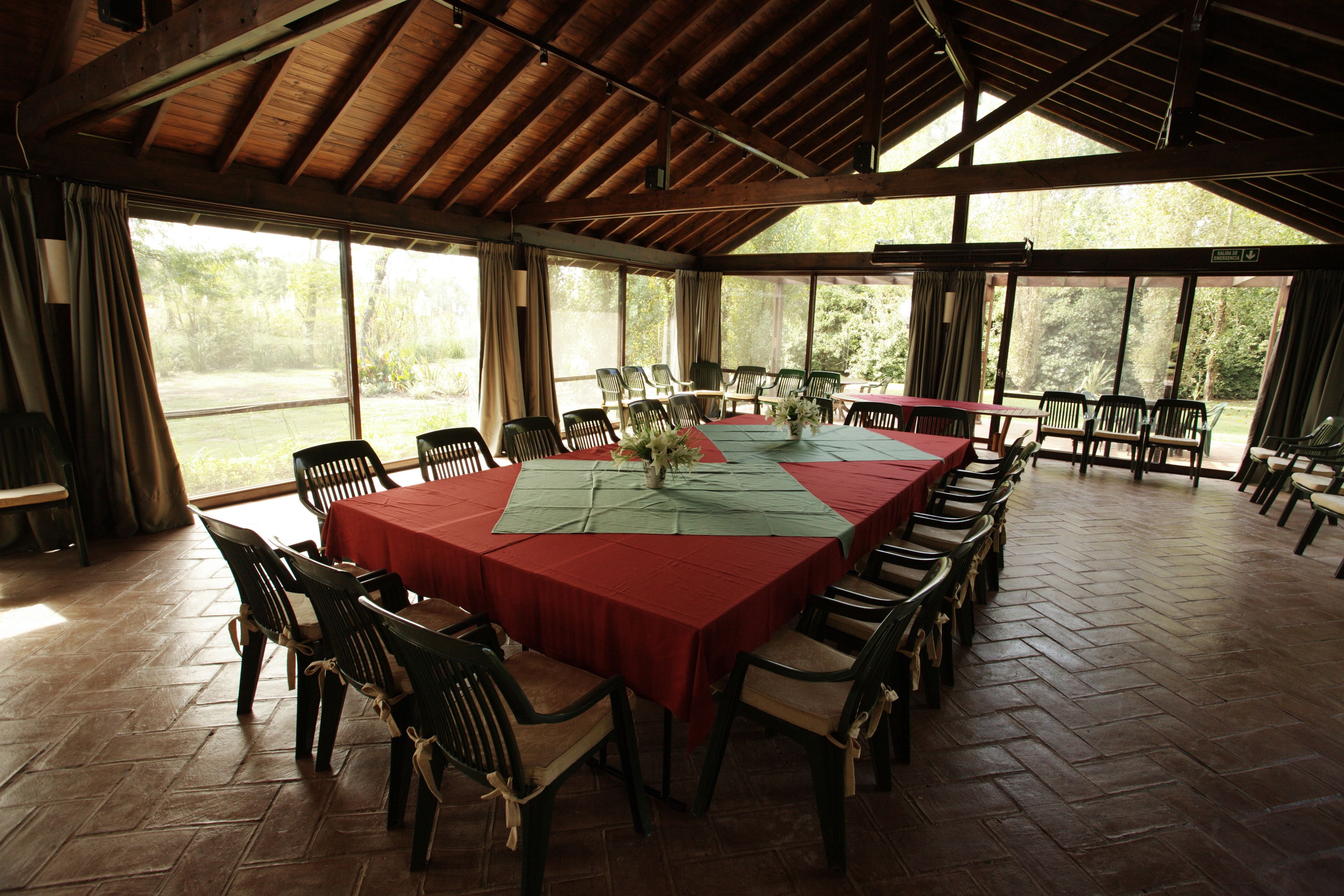 A large dining area with a long table set for a meal, surrounded by chairs.