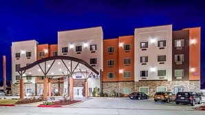 Un hotel de varios pisos con una entrada central que presenta un gran arco.