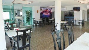 A modern dining area with glass partitions, wooden flooring, and a large mural on the wall. - Days Inn by Wyndham Minatitlan (Minatitlán)