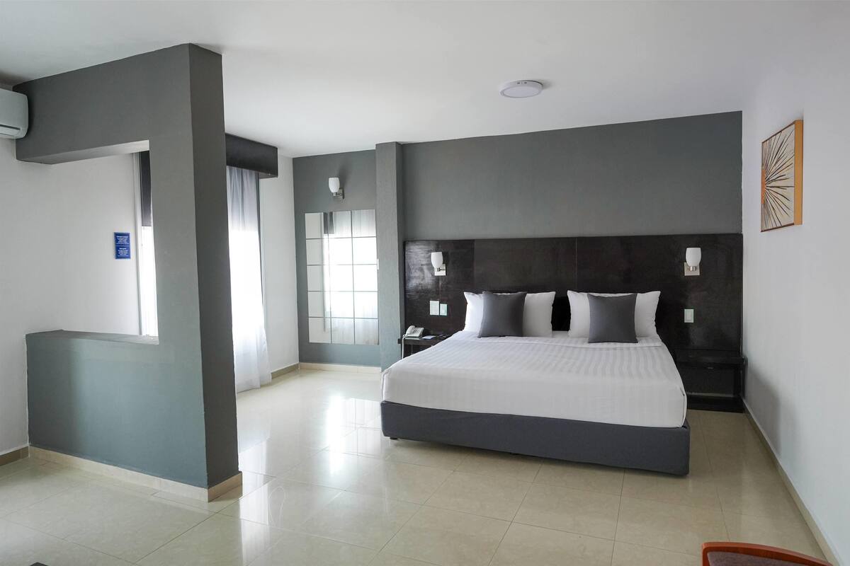 Un dormitorio moderno con una cama grande, un escritorio y una silla.