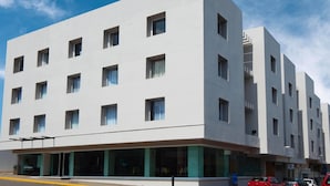 A modern building with a flat facade, multiple windows, and a ground-level entrance with glass doors. - Days Inn by Wyndham Minatitlan (Minatitlán)