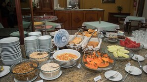 A buffet with various food items and dishes, including fruits, cereals, and desserts.