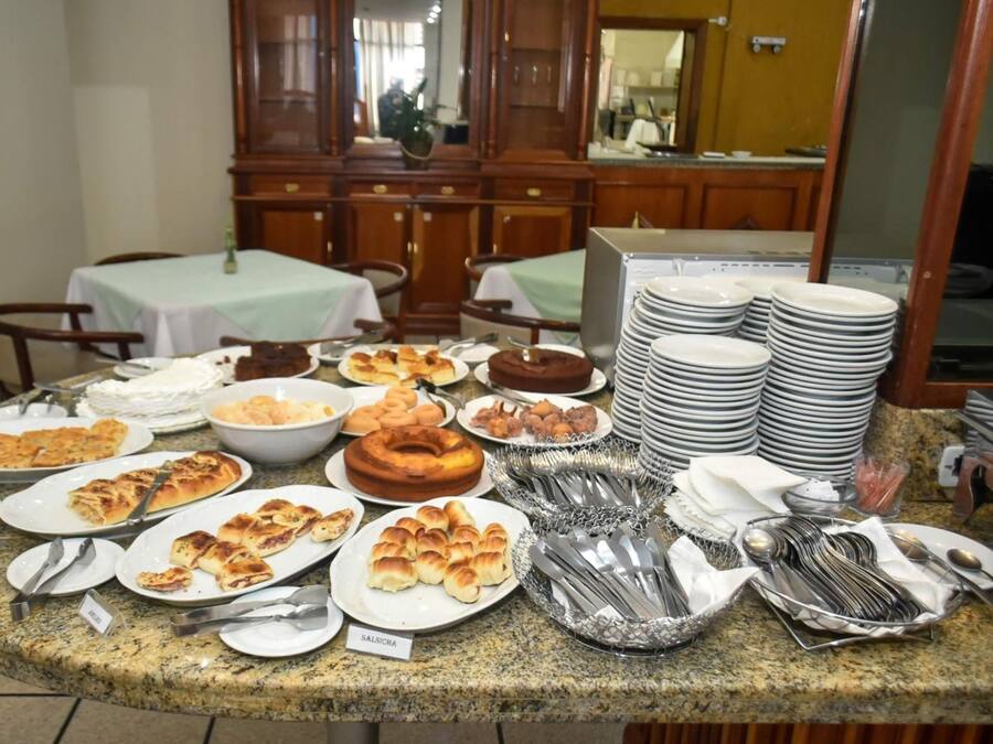 Un bufé con diversos platos y cubiertos, incluyendo platos, tazones y utensilios.